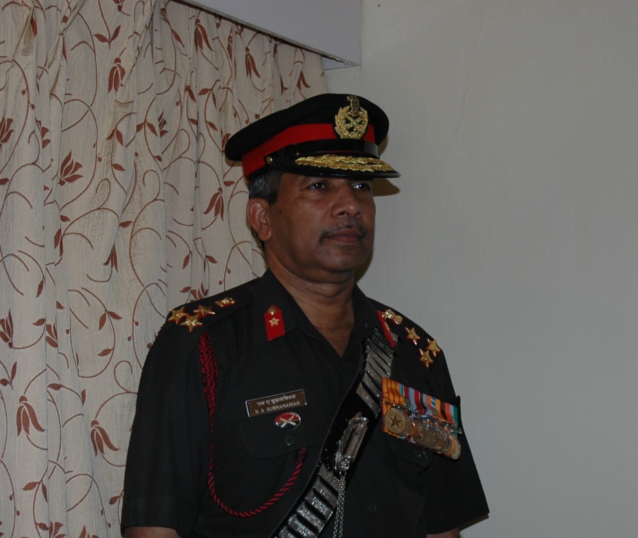 In ceremonial dress, with medals and cross-belt, as a Brigadier